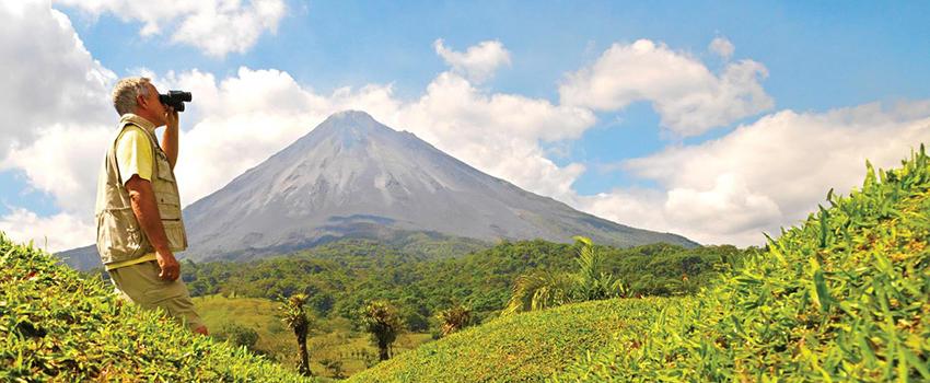 一个人在哥斯达黎加用双筒望远镜观看一座山.