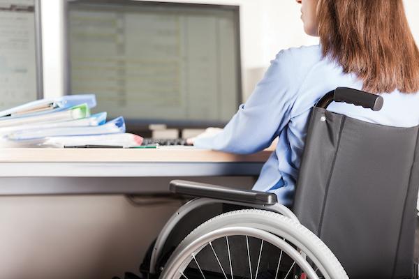坐在轮椅上的学生在电脑前工作.