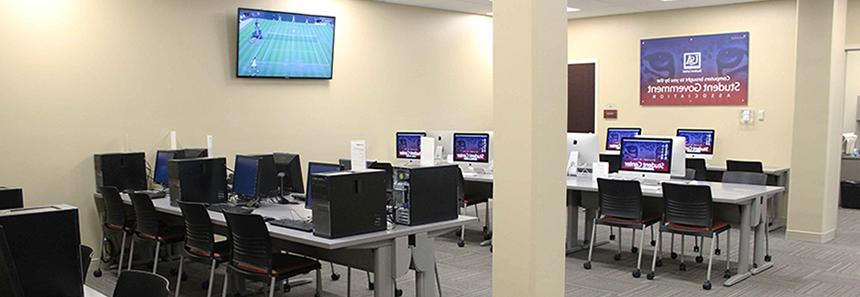 学生中心电脑室，设有电脑工作站和投影电视