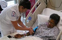 A nurse taking blood pressure of patient