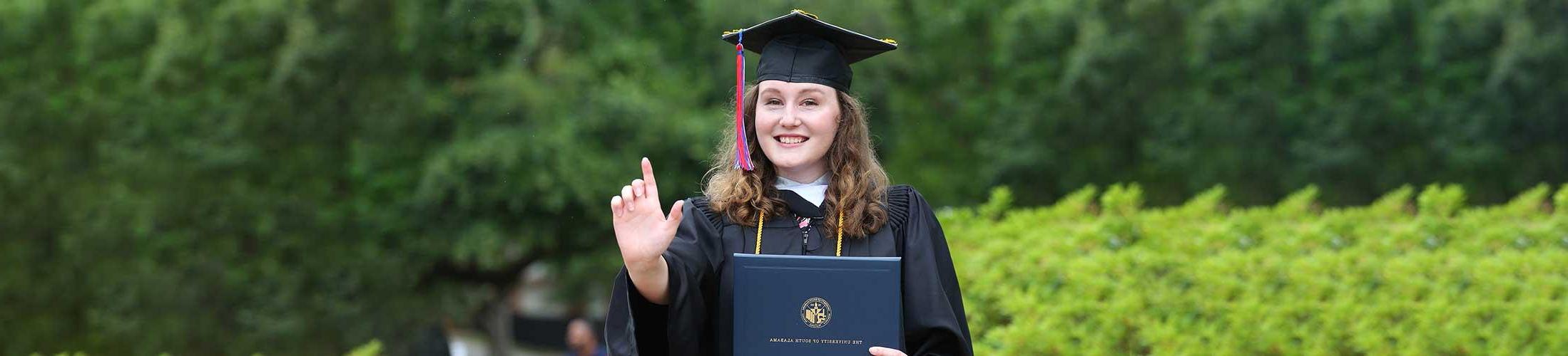 Student holding up J Sign at graduation